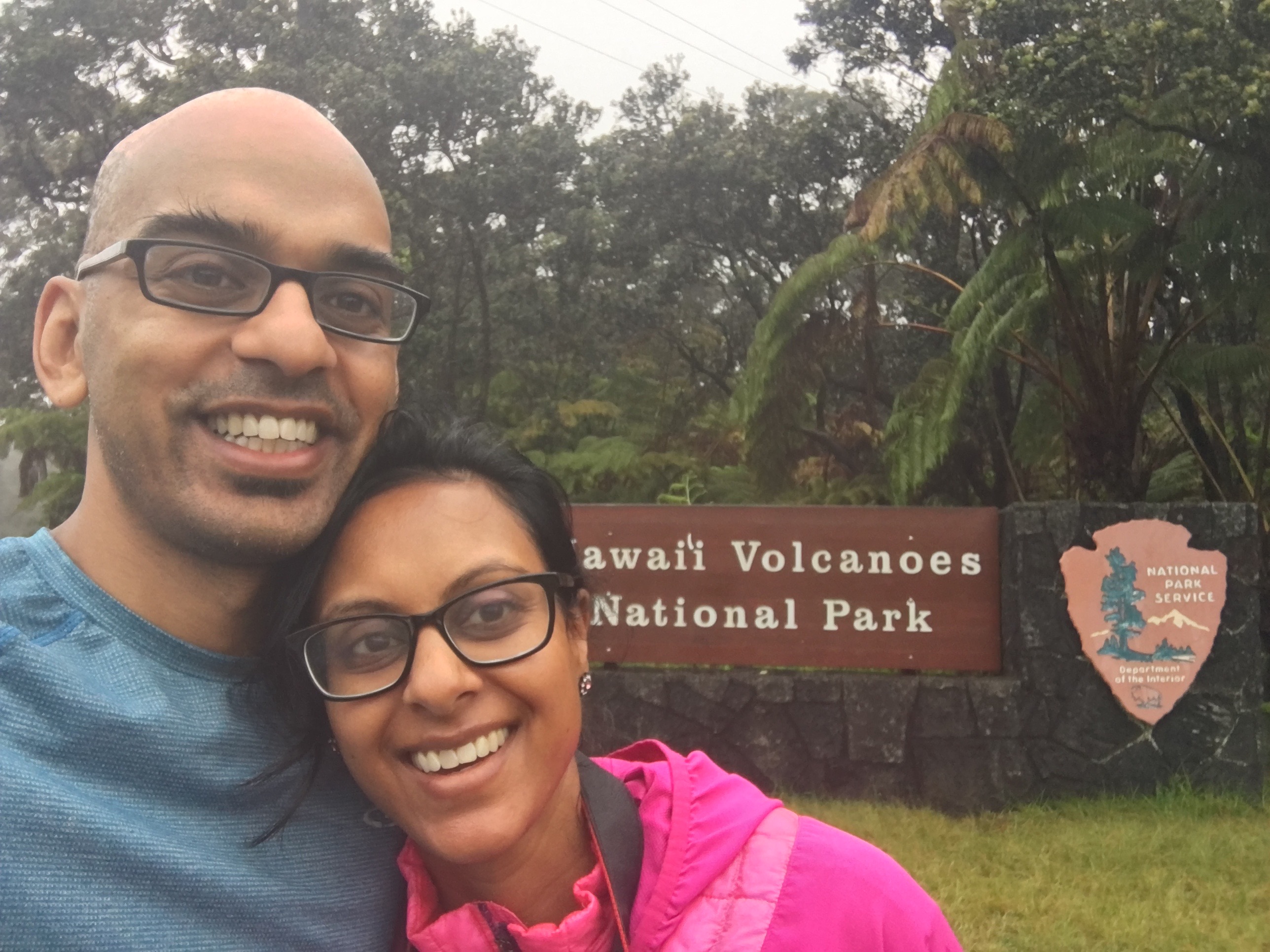 husband and wife standing in front of entrance to Hawaii Volcano National Park